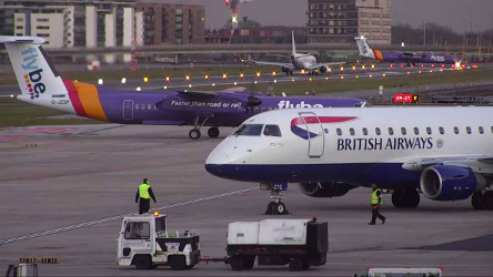 A view of the runway including service personnel and an aeroplane